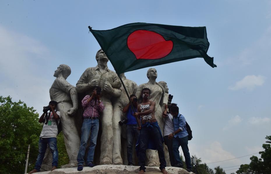 A few people gather on a statue in Bangladesh for a student demonstration